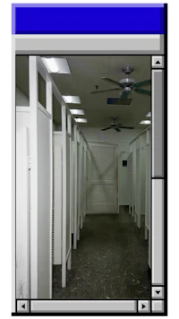 an image of a hallway with white stalls and a fan