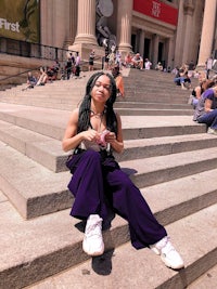 a woman sitting on steps in front of a building